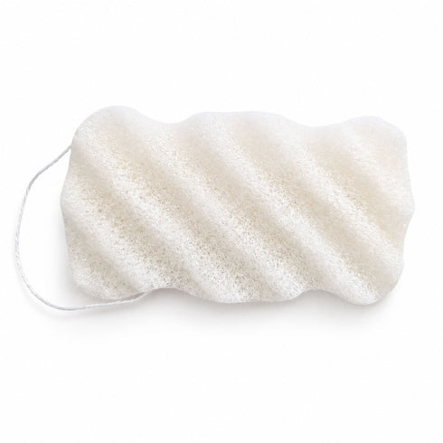 White textured konjac body sponge with diagonal ridges and a hanging string, shown on a white backdrop.