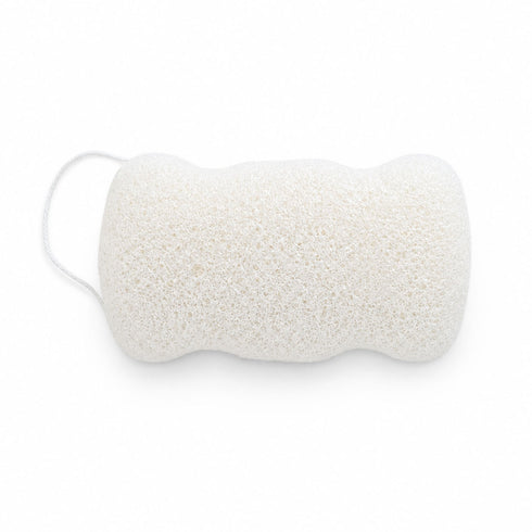 Flat, porous underside of a white konjac body sponge with an attached hanging cord, on a white surface.