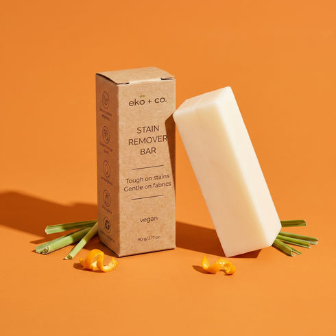 eko + co. Vegan Stain Remover Bar kraft box and bar displayed with lemongrass, orange peel, and coconut for GreenWave wholesale catalogue
