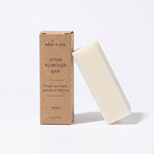 eko + co. Stain Remover Bar leaning against kraft box on white background — plastic-free solid bar format
